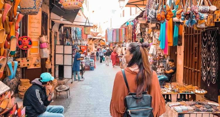 A bustling alleyway in the Fes medina, filled with shops and people.