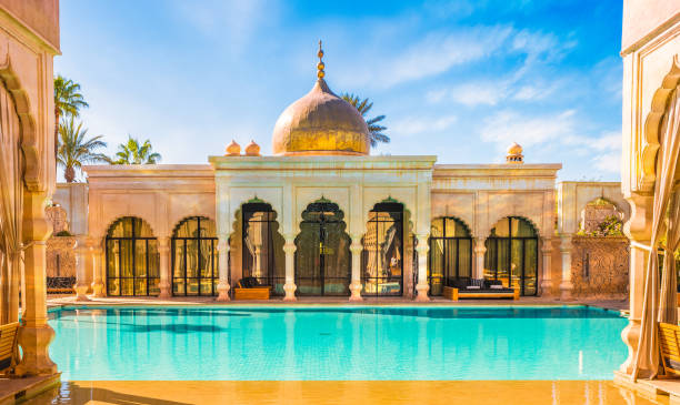 An opulent interior of a luxury riad in Marrakech with a swimming pool and intricate tilework.