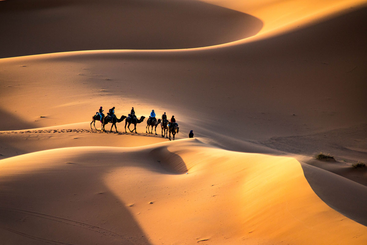 A Moroccan man in traditional clothing pouring mint tea, symbolizing Moroccan hospitality.