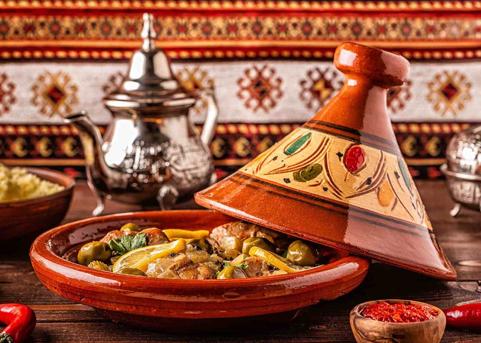 A classic Moroccan chicken tagine with olives and preserved lemons being served.