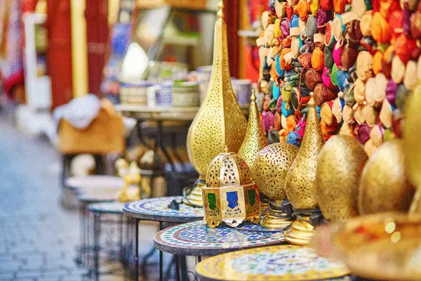 A colorful display of Moroccan ceramic plates and bowls in a souk.