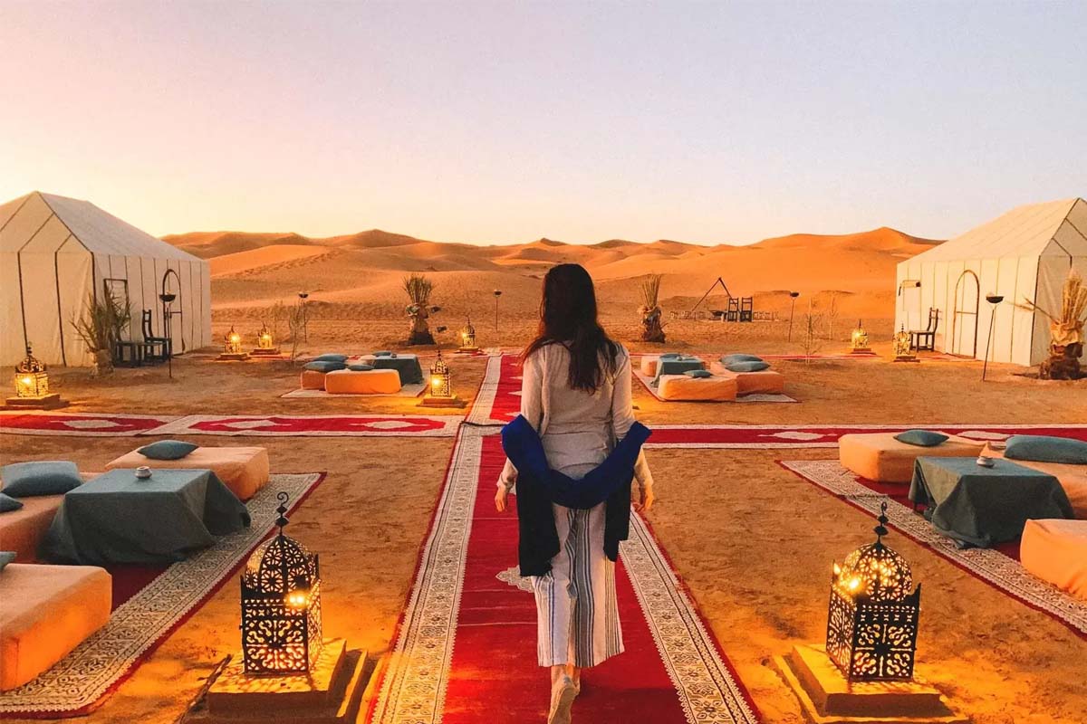 Espectacular atardecer en el desierto del Sahara con caravana de camellos
